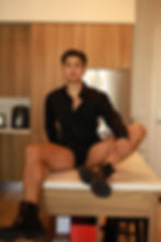 Angel Rivera, an award-winning adult performer, sits confidently in a well-lit space, exuding calm strength and resilience, symbolizing his journey through exploitation, addiction, and recovery to reclaim his power in the adult industry.