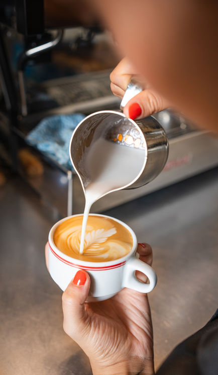 Barista pouring milk into latte art