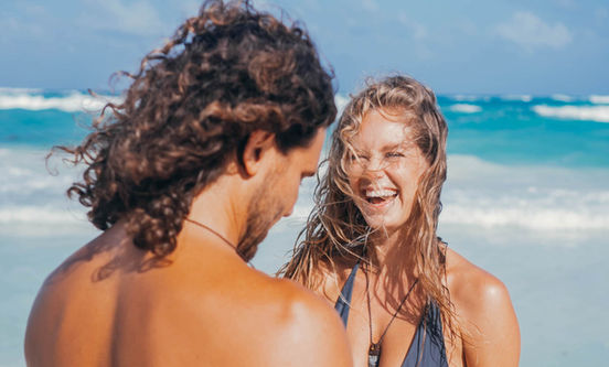 Happy couple laughing on beach