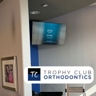 Wall-mounted TV installed inside Trophy Club Orthodontics for patient viewing, office communication, and display content.