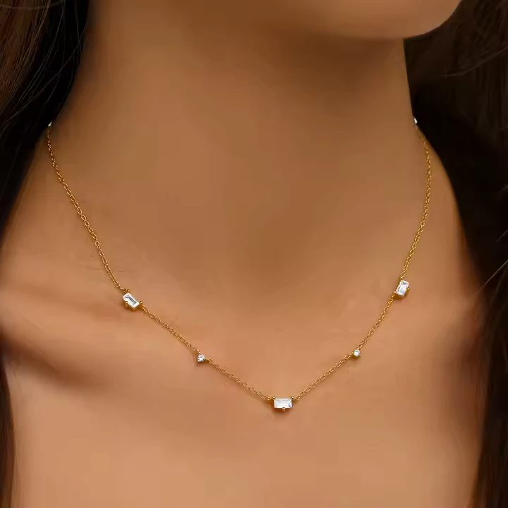 A model wearing a clavicle choker chain necklace in gold vermeil with five modern cubic zirconia set sections