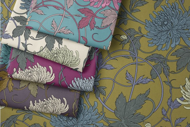 4 Folded Fabrics with Spider Chrysanthemum Floral repeat Pattern in rich bold colours in different colour ways on different backgrounds on top of another colour way with an olive background