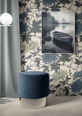 an interior scene with a wallpapered wall, a stool and a lamp. The wallpaper is Spider Chrysanthemums and leaves in bold rich colours in a repeat pattern on a cream background