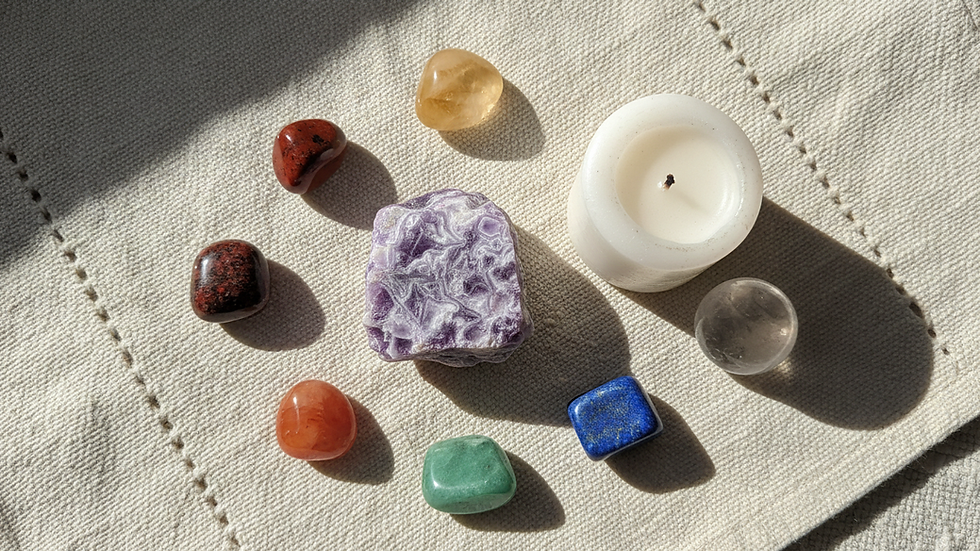 Overhead view of phosphosiderite placed near a candle and simple chakra stones.