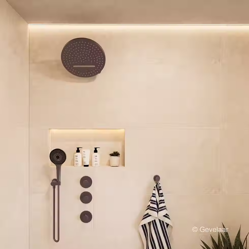 Inbouw regendoucheset met donkere ronde douchekop aan wandarm in moderne badkamer