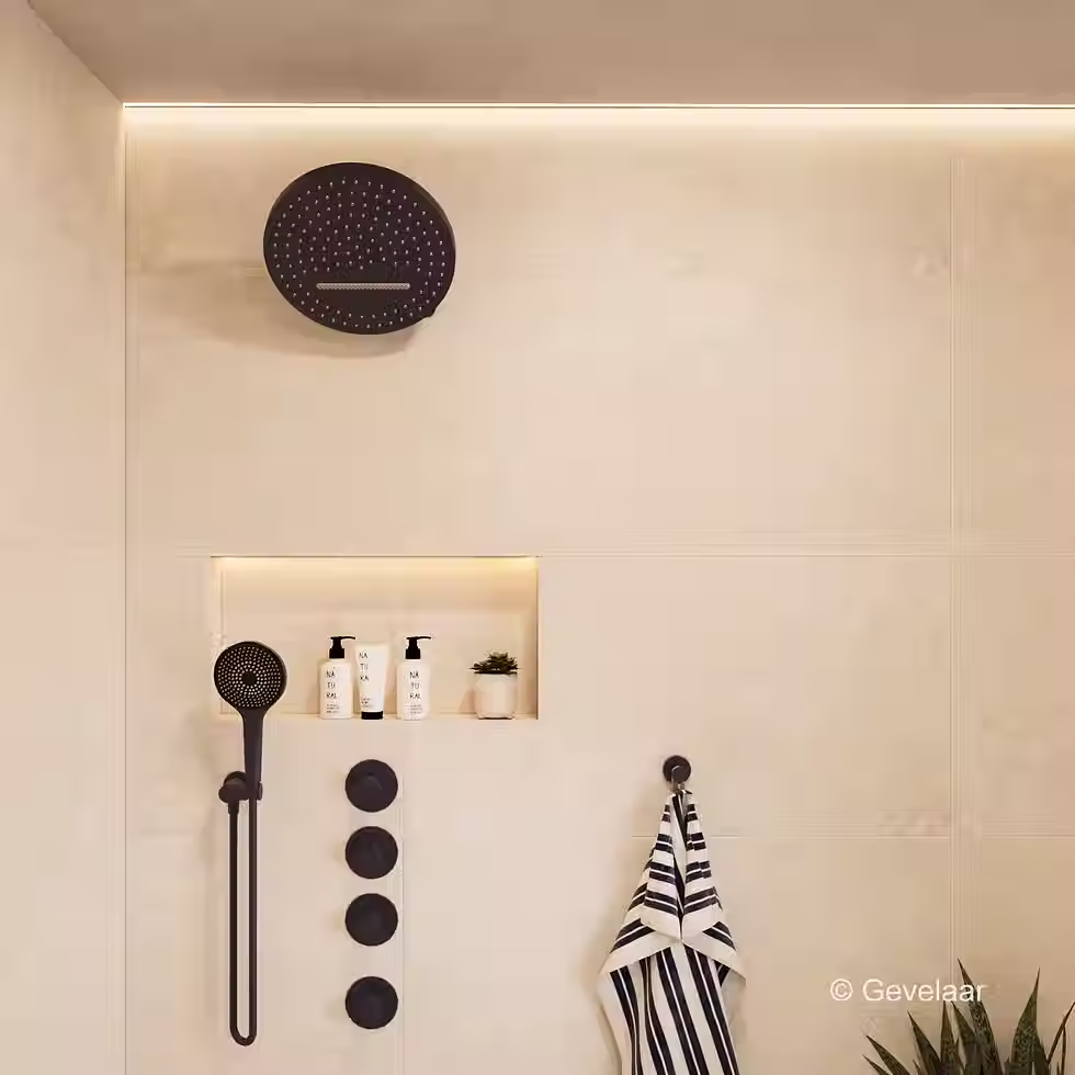 Inbouw regendoucheset met donkere ronde douchekop aan wandarm in moderne badkamer