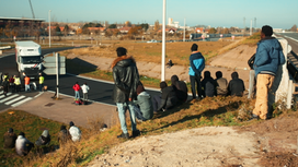 des jeunes réfugiés Érythréens attendent des camions près de la rocade à Calais
