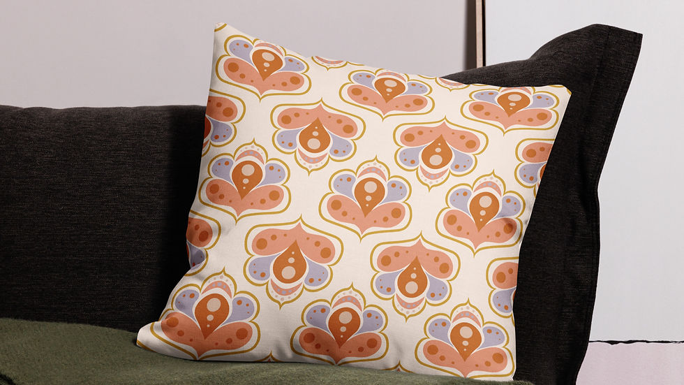 Decorative pillow with orange and purple patterns rests on a dark gray couch with a green blanket. Neutral background.