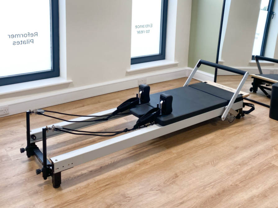 Pilates reformer machine in light and airy studio, Renu Studios with windows in background