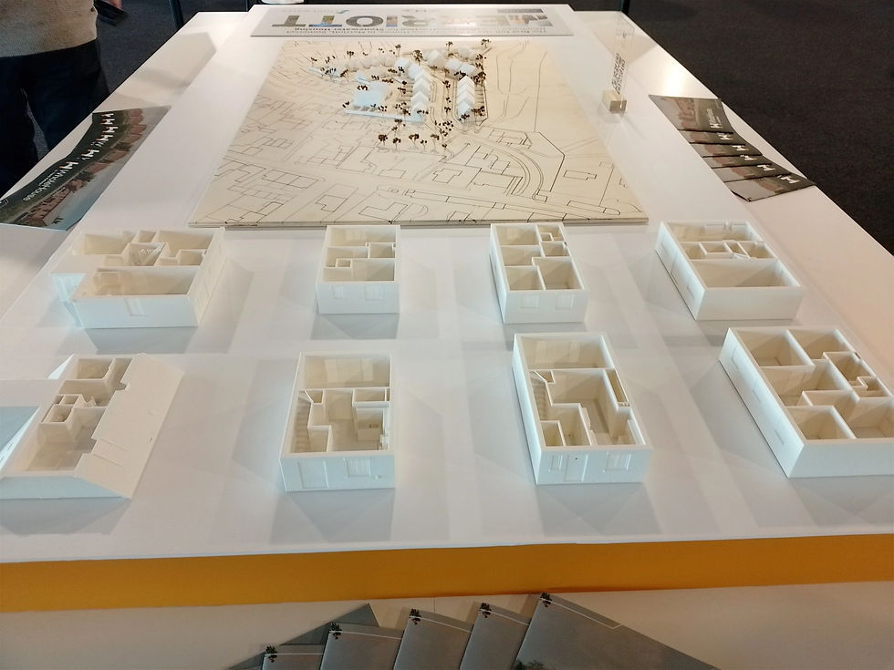 3D prints of the Travis Perkins WholeHouse house type range, with a model of a site layout in the background.
