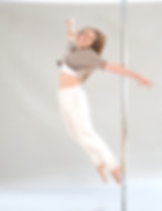 Eine Tänzerin springt von der Poledance Stange.