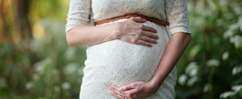 lady in white dress holding her pregnant belly