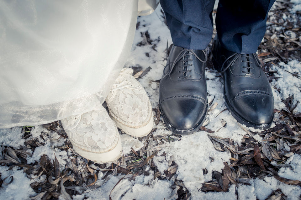 Photo from above of bride and groom hiking shoes on snowy ground