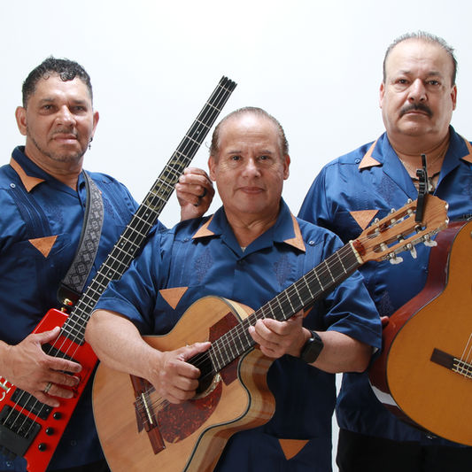  Trio Mariachi Tepatitlán posing with guitars in front of a solid white background.
