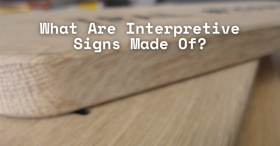 Close-up of a wooden sign with blurred background. Text reads, "What Are Interpretive Signs Made Of?" in white. Warm tones.