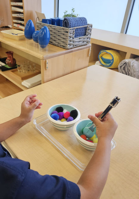 Niño dibujando con bolígrafo y cuencos con bolas coloridas, Casa De Niños Popular.