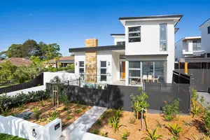 a white house with a black fence in front of it