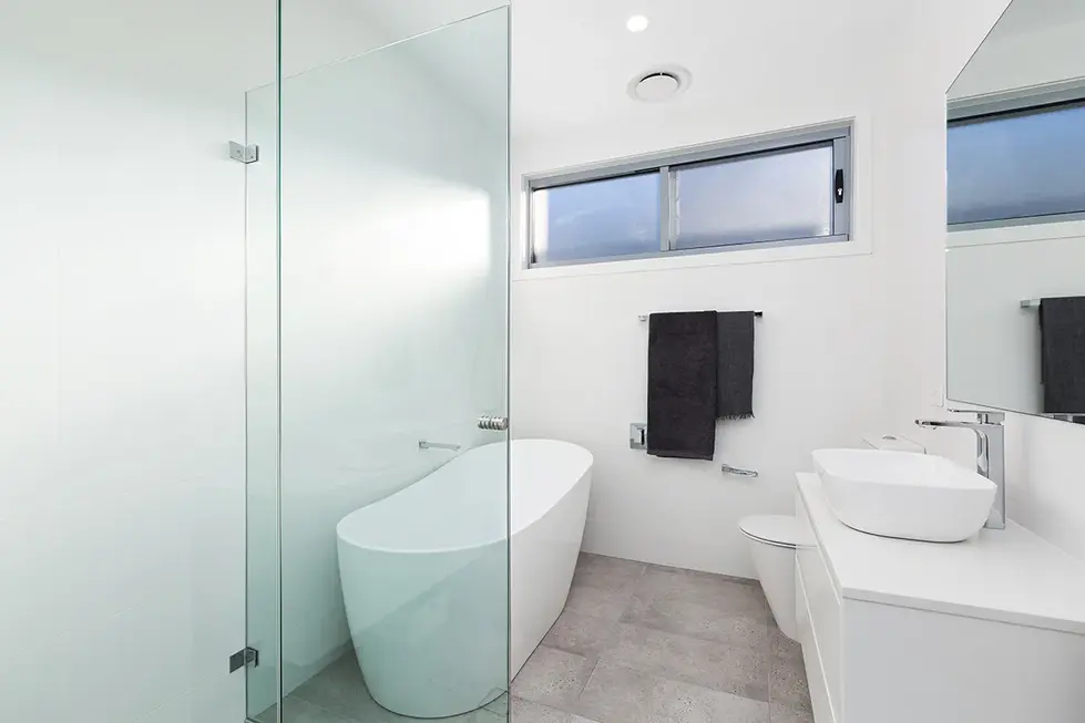Modern bathroom with freestanding bathtub, shower, and vanity.