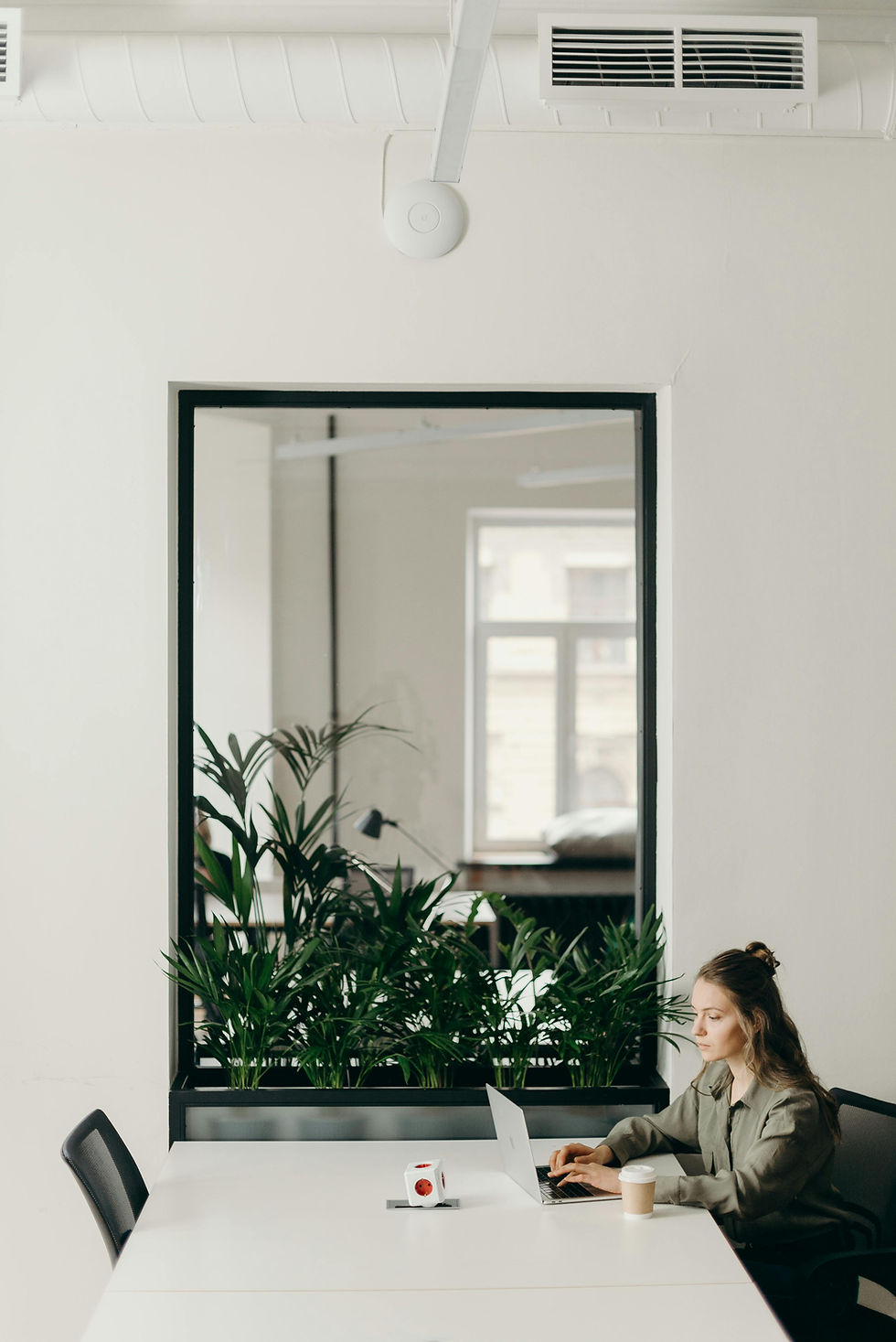 Woman working on computer in white room
