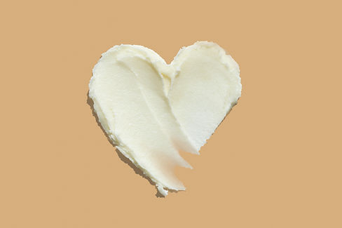 Shea butter cream textured heart shape smear on beige brown colour background, hair and skin care love swatch.jpg
