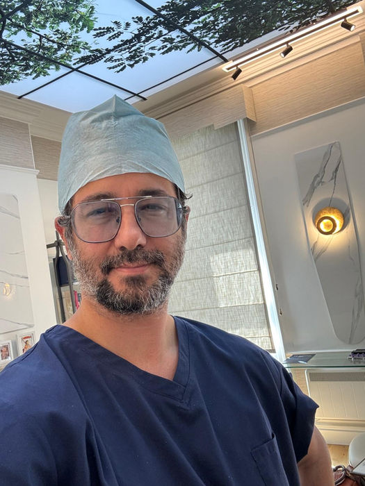 Prof. Dr. Suleyman Tas wearing surgical scrubs in a clinical setting