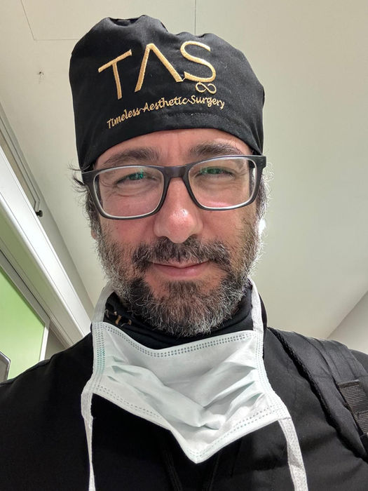 Close-up portrait of Prof. Dr. Suleyman Tas wearing surgical scrubs