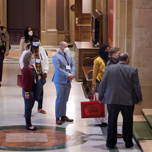 Electors must show ID and then are shown to their seat in the House Chamber.