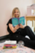 Smiling woman holds a book with a yoga pose