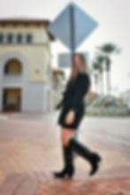 Team member in black dress and boots, smiling outdoors