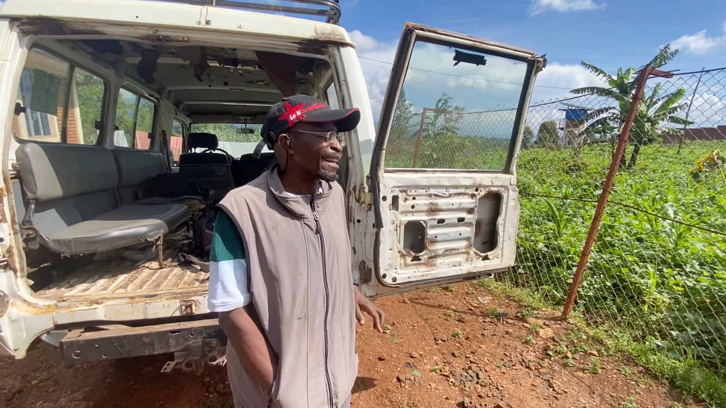 Un missionnaire congolais pose devant un véhicule tout-terrain au cœur de la nature, indispensable pour atteindre les zones reculées après les pluies.