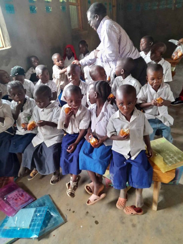 Enseignement en classe à Kisiza avec une maîtresse et des élèves concentrés, preuve du succès du projet éducatif.