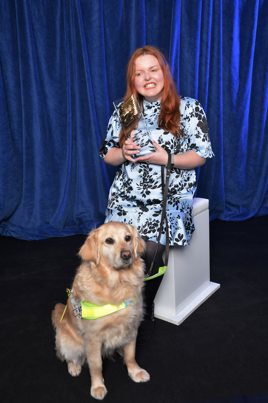 Lucy holding her RTS Breakthrough Presenter Award. The award is clear plastic with a golden face in profile