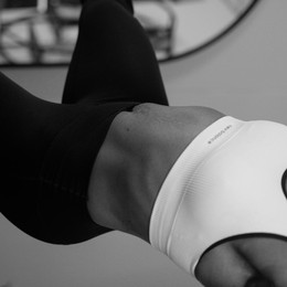 Exercice de gainage Pilates Reformer en noir et blanc studio Montpellier