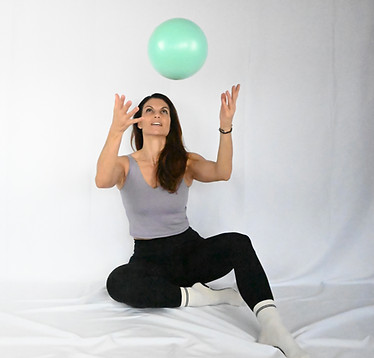Gilda pratiquant du pilates au sol avec un ballon