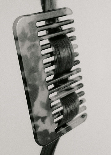A comb featuring a black and white image of a comb, representing hair salon tools and equipment.