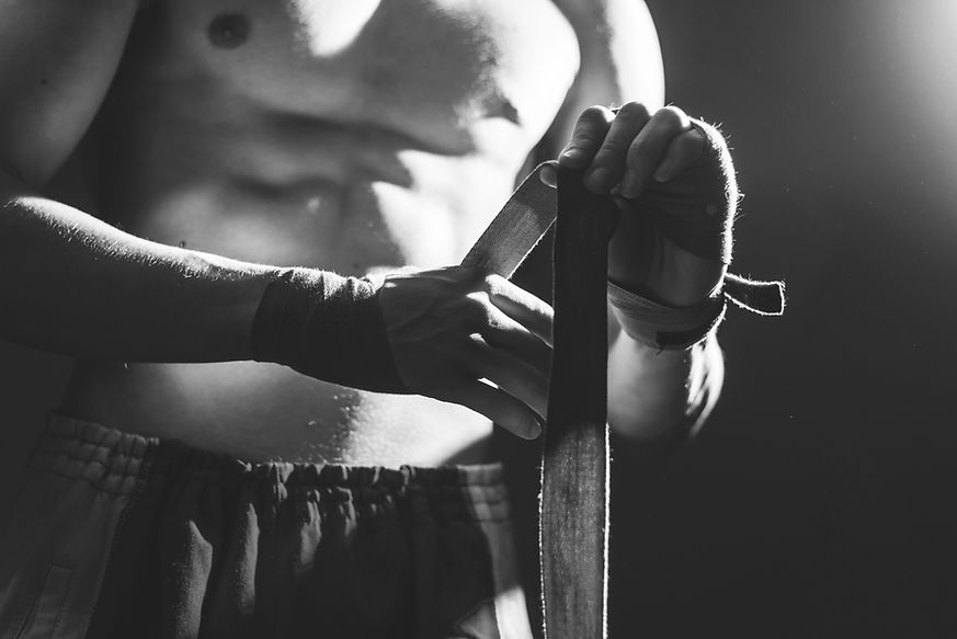 Black and white photography of athlete applying tape on the hands, closeup.jpg