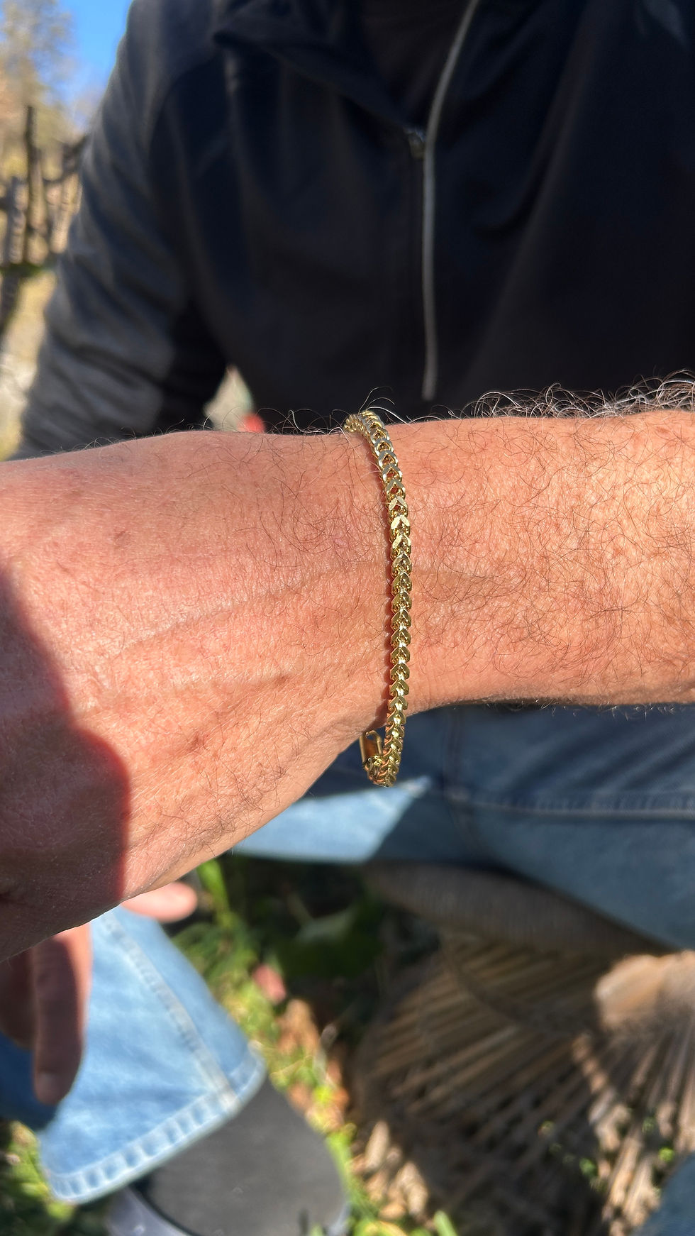 Close-up of a man's arm wearing the gold Waterproof Chain Bracelet outdoors in natural light, showcasing the secure clasp and