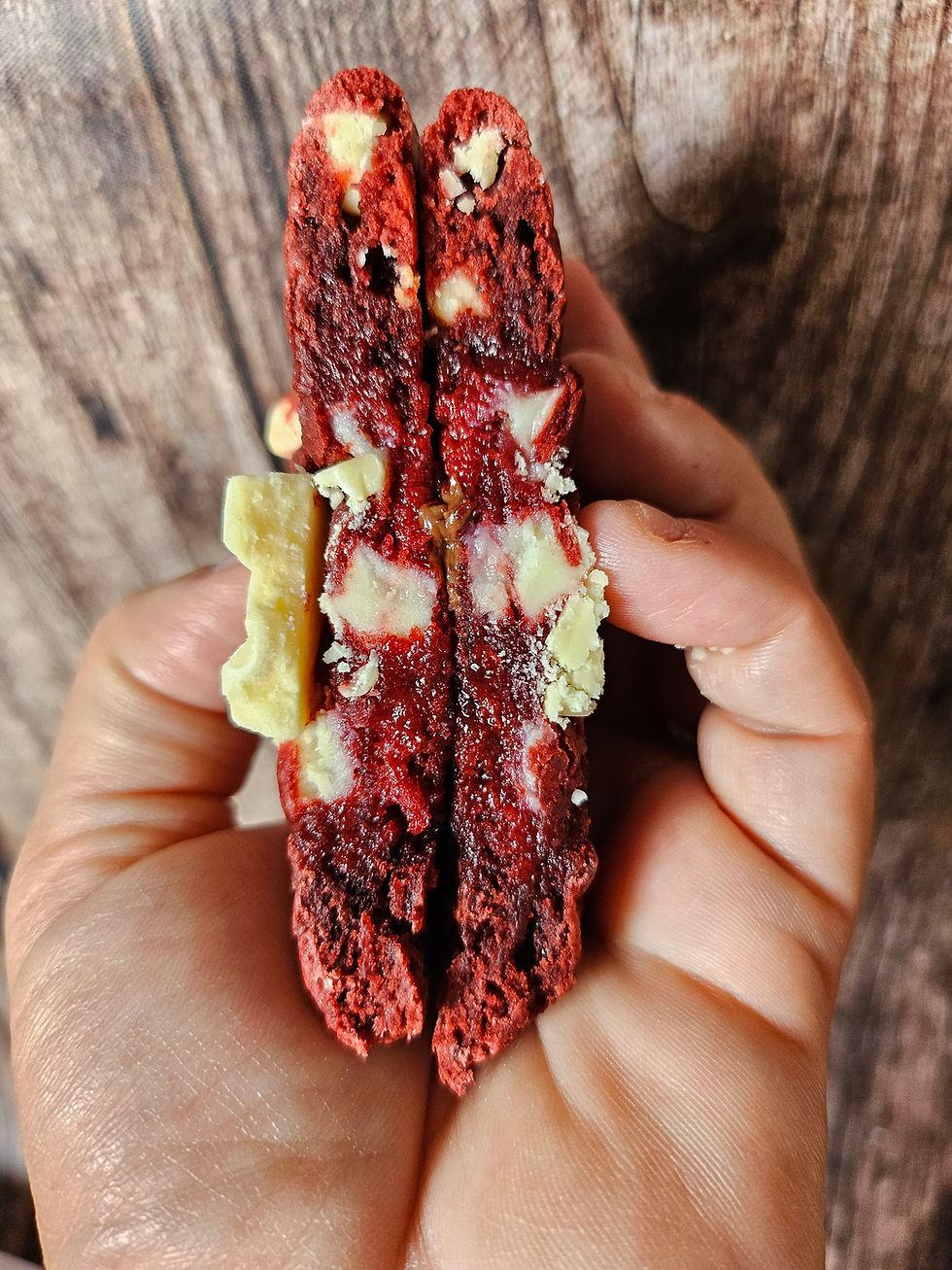 Miniature : découpe du cookies Red velvet avec une couleur rouge intense et veloutée, pépites de chocolat blanc et un insert framboise