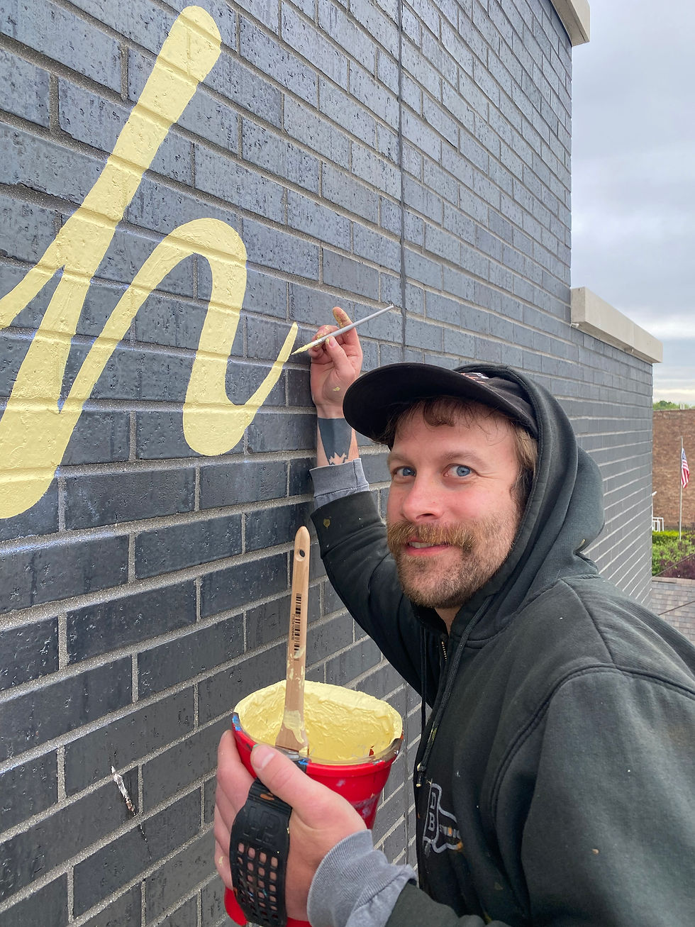 sign painter working on the letter h