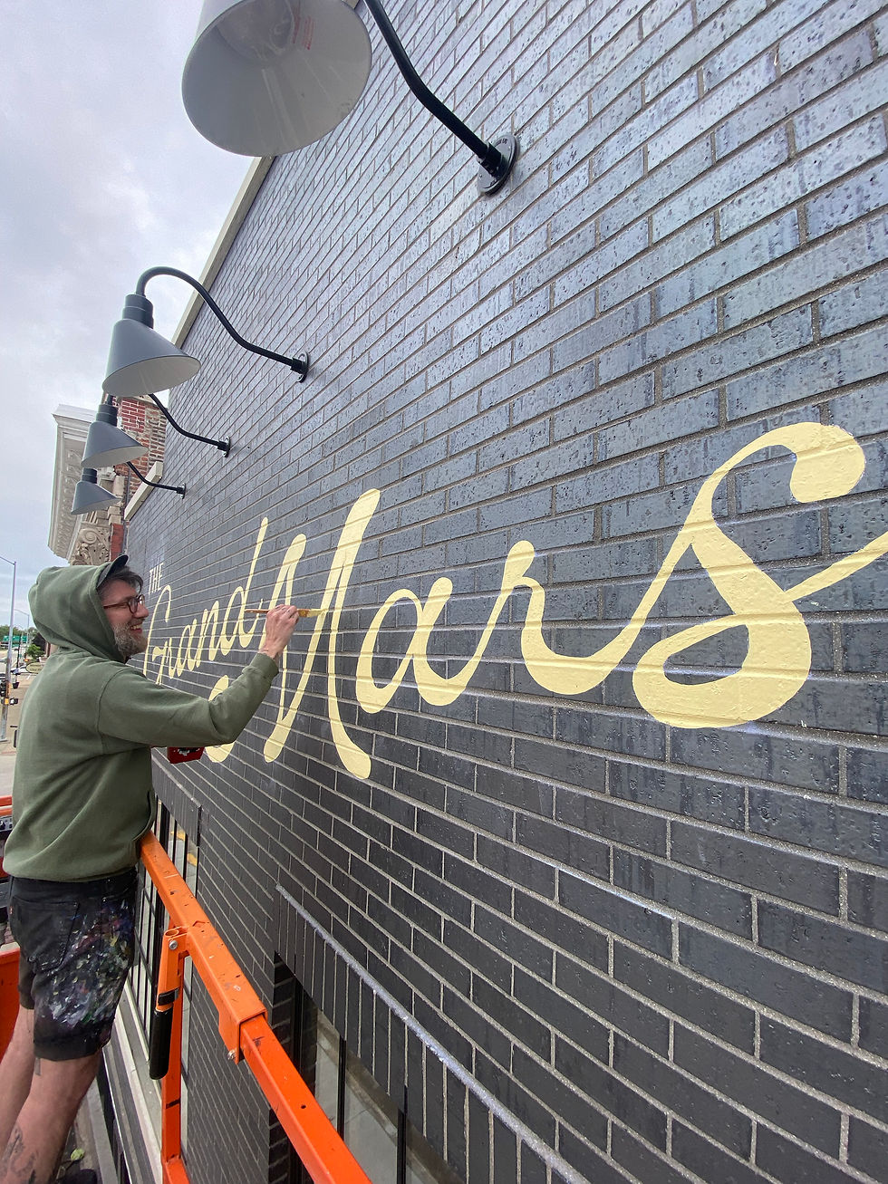 sign painter working on sign