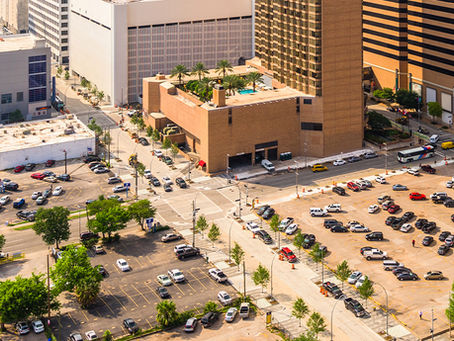Aerial view of busy downtown Houston parking lots, highlighting the need for affordable event parking like 1112 Clay Garage.