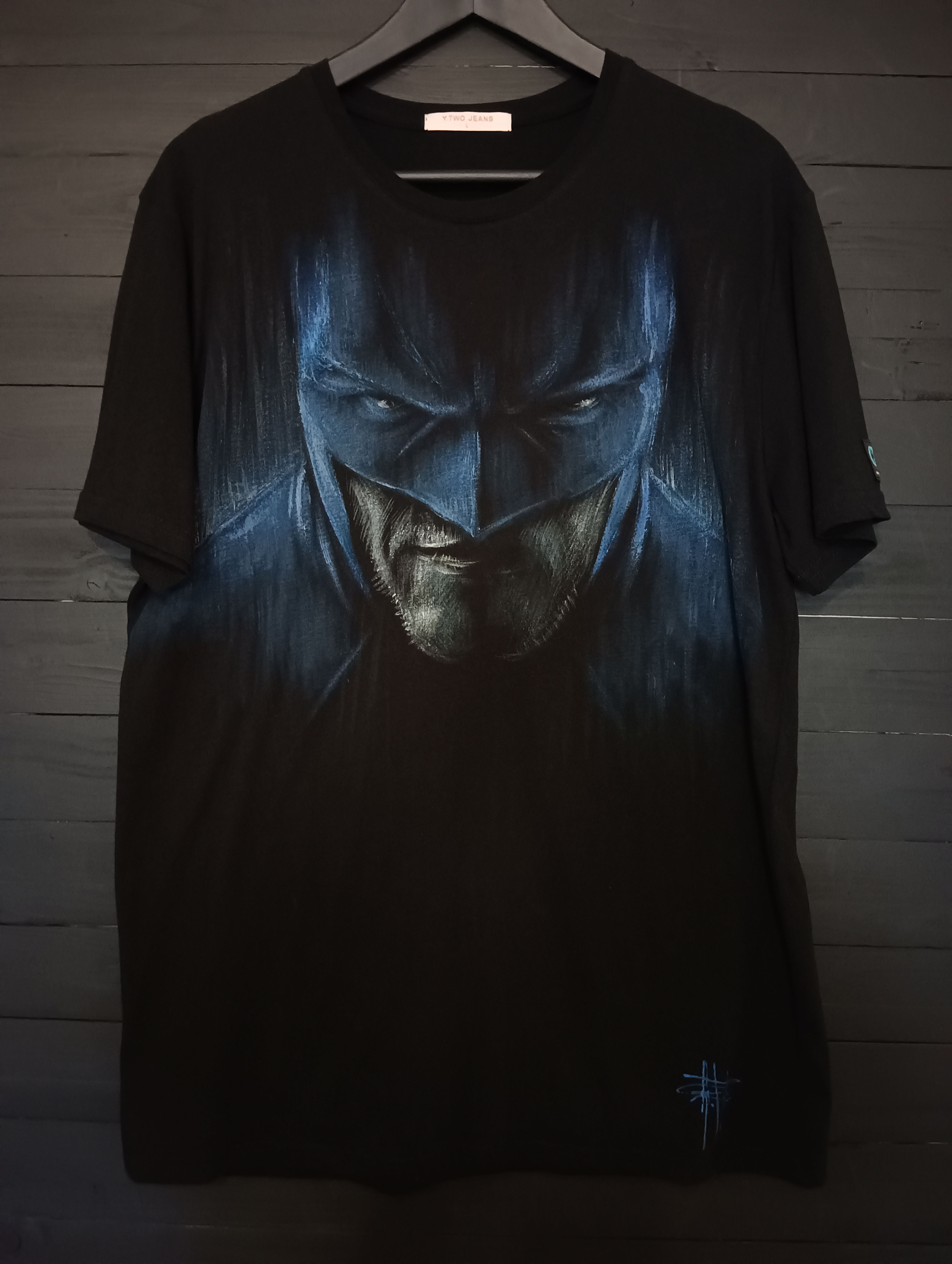 T-shirt personalizzata dipinta a mano Batman nera in cotone/cotone biologico modello uomo/unisex a maniche corte a girocollo disegno viso di Batman con maschera nei toni dell'azzurro vista frontale