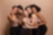 five-pretty-african-caucasian-women-brown-tops-black-jeans-look-camera-beige-background.jp