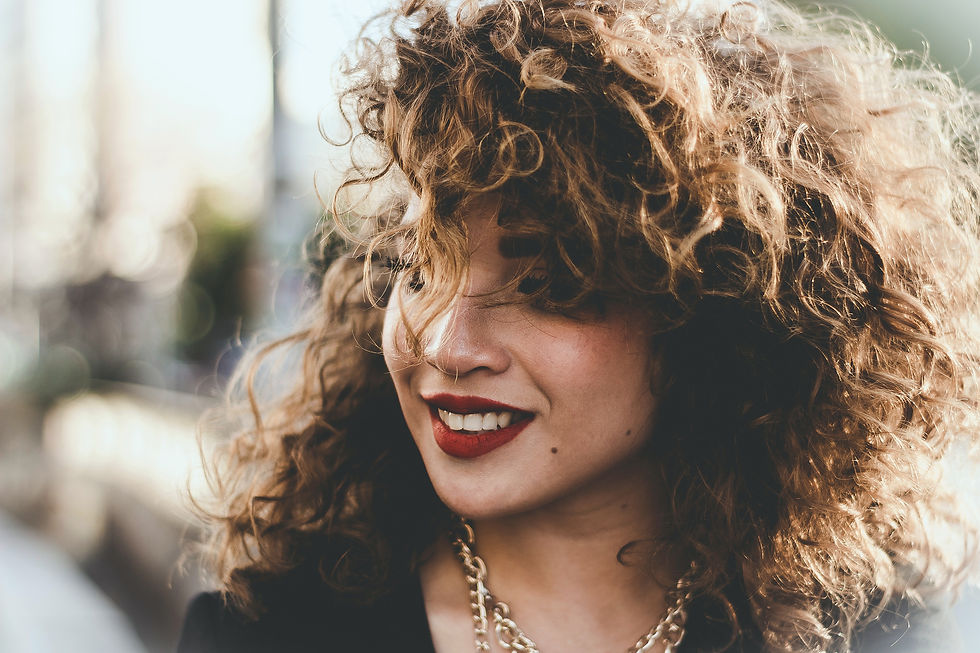 girl with curly hair smiling.