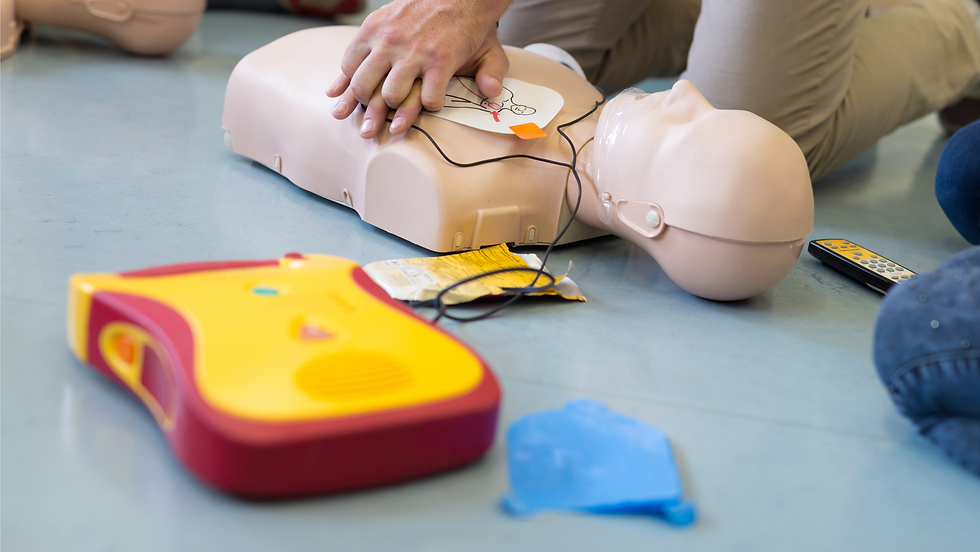 AED trainer being used on a manikin receiving CPR compressions to the chest. .
