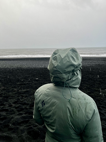 Standing on Reynisfjara Black Sand Beach in Vik, Iceland in the rain watching the sneaker waves