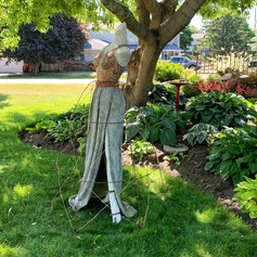 Vintage mannequin used as garden trellis. Features glass mosaic bodice, concrete skirt and metal frame trellis over skirt.