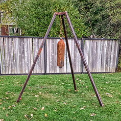 Garden bell made from scuba tank. Hanging with metal chain and suspended from a 7 foot tall metal tripod.