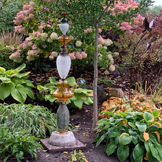 Garden totem made from vintage glass lamp parts with concrete base