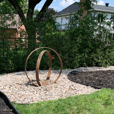 Garden art made with crossed antique wagon wheel rims